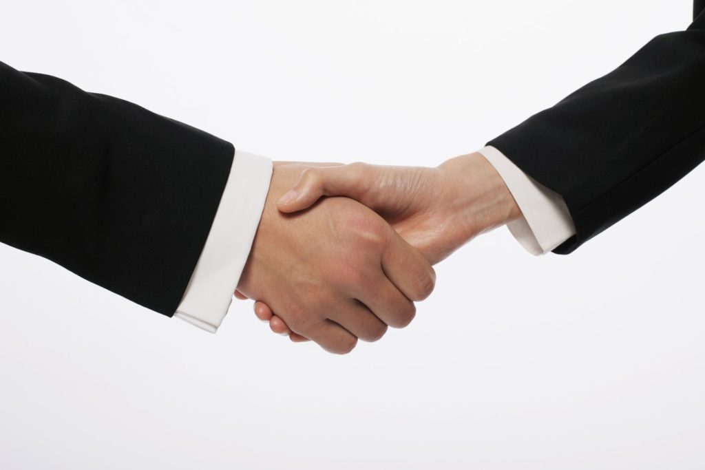 Handshake representing successful negotiation between postdoc and supervisor about a senior authorship